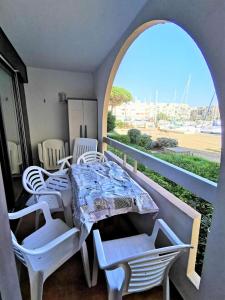 einen Tisch und Stühle auf einem Balkon mit Aussicht in der Unterkunft Résidence TERRASSES DE LA MEDITERRANEE 1 - 2 Pièces pour 4 Personnes 64 in Port Leucate