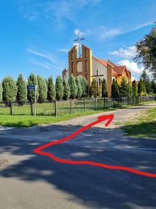 uma linha vermelha numa estrada em frente a uma igreja em Oława Chabrów em Olawa