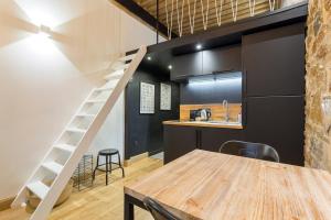 a kitchen with a wooden table and a staircase in a room at Hamac Suites - studio Ainay 1 - hyper centre Lyon in Lyon