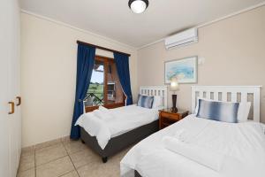 a bedroom with two beds and a window at San Lameer Villa 10415 - 2 Bedroom Classic - 4 pax - San Lameer Rental Agency in Southbroom
