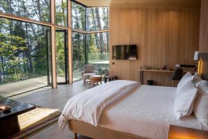 ein Schlafzimmer mit einem großen Bett und einem großen Fenster in der Unterkunft Las Balsas Relais & Chateaux in Villa La Angostura
