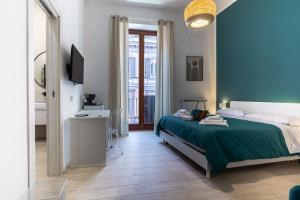 a bedroom with a bed and a television in it at RUA DE MAR CHIATAMONE in Naples