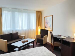 una camera d'albergo con letto, scrivania e divano di Landhotel Weisses Ross garni a Bad Brückenau
