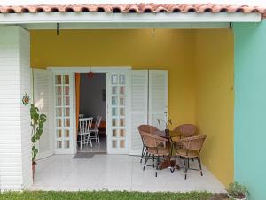 une terrasse avec une table et des chaises à côté d'une maison dans l'établissement Casas Amarelas Ingleses, à Florianópolis