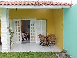 une terrasse avec une table et des chaises à côté d'une maison dans l'établissement Casas Amarelas Ingleses, à Florianópolis