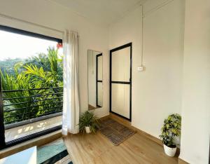 an empty room with a large window and plants at Sky Studio Apartments by Blue Sky Homes in Canacona