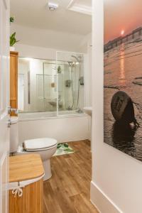 a bathroom with a toilet and a bath tub at Brighton & Hove Beach - group or family fun in Brighton & Hove