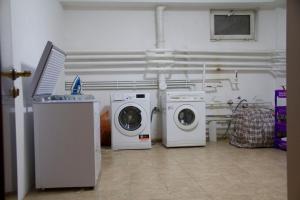 two washing machines and a washer and dryer in a room at Apple tree in Almaty