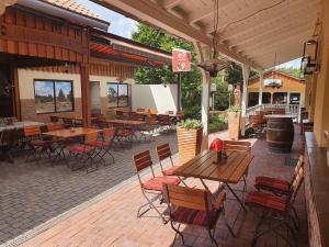 un patio extérieur avec des tables et des chaises en bois dans l'établissement Ferienpark Auf dem Simpel - Heide-Lodge 1, à Soltau