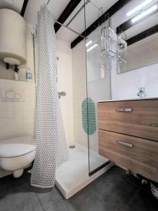 a bathroom with a toilet and a glass shower at Résidence LES MAISONS DU PORT - Maisons & Villas pour 6 Personnes 44 in Port Leucate