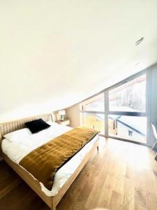 a bedroom with a large bed and a large window at Chalet Du Jardin Alpin Ii - 3 Pièces pour 4 Personnes 794 in Val-d'Isère