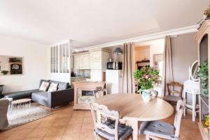 uma sala de estar com uma mesa e um sofá em Village Pont Royal en Provence - maeva Home - Appartement ravissant 3 Pièces 7 em Mallemort