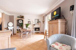 uma sala de estar com uma mesa e uma televisão na parede em Village Pont Royal en Provence - maeva Home - Appartement ravissant 3 Pièces 7 em Mallemort