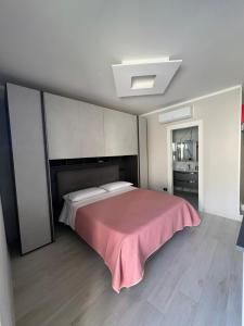 ein Schlafzimmer mit einem Bett mit einer rosa Decke in der Unterkunft Brass apartment in Castellammare di Stabia