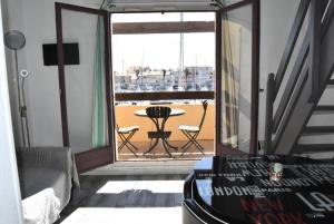 Habitación con sofá y balcón con mesa. en Résidence LES PORTES DE LA MEDITERRANEE - Studio pour 4 Personnes 14, en Port Leucate