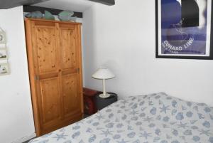 1 dormitorio con 1 cama y armario de madera en Résidence LES PORTES DE LA MEDITERRANEE - Studio pour 4 Personnes 14, en Port Leucate