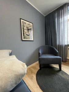 a bedroom with a chair next to a bed at Zimmer in der Altstadt in Bielefeld