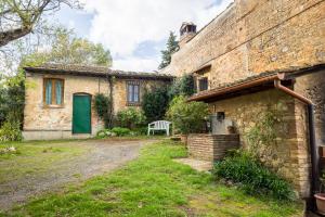 una casa de ladrillo con una puerta verde y un banco en Countryhouse in San Gimignano, en San Gimignano