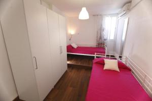 een kleine kamer met twee rode bedden. bij Arce apartamentos in Sevilla