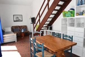 ein Esszimmer mit einem Holztisch und Stühlen in der Unterkunft Résidence LES PATIOS 1 - Maisons & Villas pour 6 Personnes 924 in Port Leucate