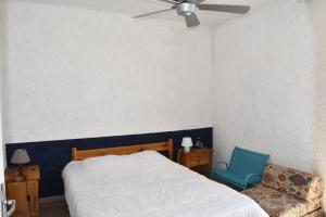 ein Schlafzimmer mit einem Bett und einem blauen Stuhl in der Unterkunft Résidence LES PATIOS 1 - Maisons & Villas pour 6 Personnes 924 in Port Leucate
