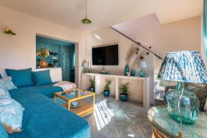 sala de estar con sofá azul y TV en Romantic rooftop apartment with stunning sea and mountain views, en Marbella
