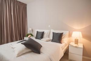1 dormitorio con 1 cama blanca grande con almohadas en Apartments Deja Views, en Split