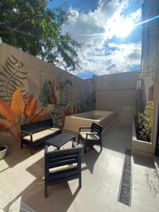 a patio with benches and a wall with a mural at Hotel Caseros Salta in Salta