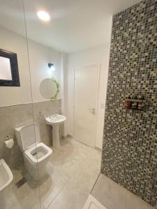 a bathroom with a toilet and a sink at Hotel Caseros Salta in Salta