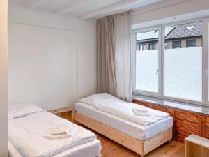 two beds in a room with a window at T&K Apartments - 5 Zimmer Einfamilienhaus 15min to Messe Fair DUS - Willich in Willich