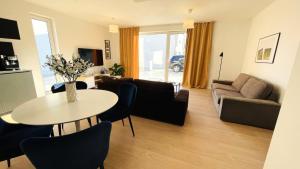 uma sala de estar com uma mesa e um sofá em House FLOW, 3 room with terrace, free 2 parking em Bratislava