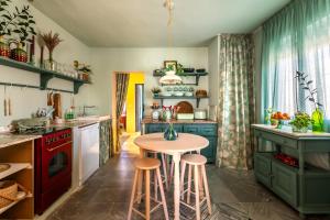 una cocina con armarios verdes, mesa y taburetes en Romantic rooftop apartment with stunning sea and mountain views, en Marbella