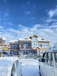 una furgoneta blanca estacionada frente a una casa en THE GULMARG PALACE en Gulmarg