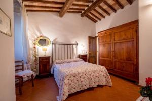 1 dormitorio con 1 cama y armarios de madera en Countryhouse in San Gimignano, en San Gimignano