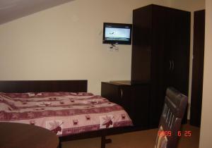 a bedroom with a bed and a tv on the wall at Pokoje Gościnne Wejherowo in Wejherowo