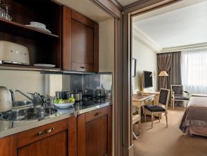- une cuisine avec un évier et un bureau dans la chambre dans l'établissement Royal Manotel, à Genève