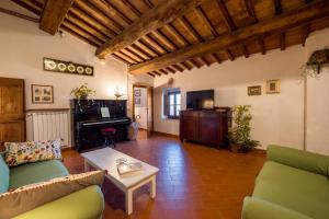 sala de estar con sofá, mesa y piano en Countryhouse in San Gimignano, en San Gimignano