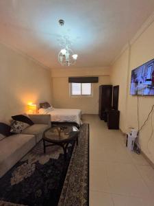 a living room with a couch and a bed at Fully furnished studio apartment in Ajman 