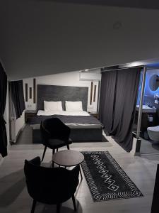 1 dormitorio con 1 cama, 2 sillas y 1 alfombra en womco butik otel, en Estambul