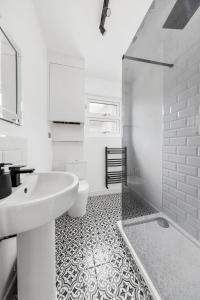 a white bathroom with a sink and a toilet at Stylish 2-Bedroom Flat in Walthamstow in London