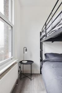 sypialnia z łóżkiem piętrowym i stołem obok okna w obiekcie Stylish 2-Bedroom Flat in Walthamstow w Londynie