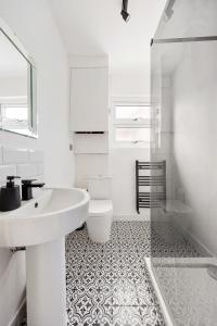a white bathroom with a sink and a toilet at Stylish 2-Bedroom Flat in Walthamstow in London