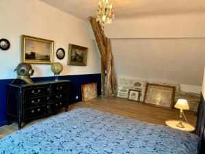 een slaapkamer met een blauw bed en een kroonluchter bij Château de la Pervenchère gîte Marin in Casson