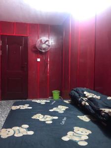 a red room with a bed with tigers on it at The Big Boss Indian & Nepali Restaurant house in Sihanoukville