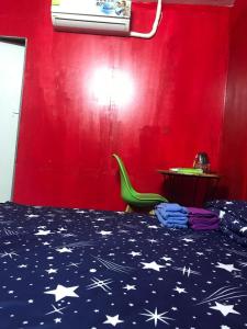 1 dormitorio con cama y pared roja en The Big Boss Indian & Nepali Restaurant house, en Sihanoukville