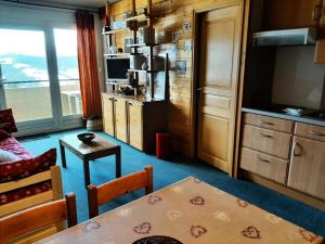 a living room with a table and a kitchen with a window at Résidence Les Glovettes - 2 Pièces pour 6 Personnes 614 in Villard-de-Lans