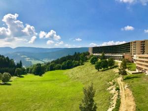 a green field with buildings and mountains in the background at Résidence Les Glovettes - 2 Pièces pour 6 Personnes 614 in Villard-de-Lans