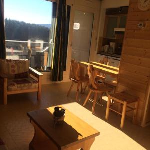 un soggiorno con tavolo, sedie e finestra di Résidence Les Glovettes - 2 Pièces pour 6 Personnes 624 a Villard-de-Lans