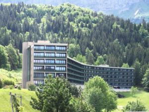 un gran edificio frente a una montaña con árboles en Résidence Les Glovettes - 2 Pièces pour 6 Personnes 624 en Villard-de-Lans