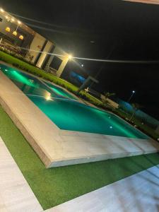 a swimming pool at night with green illumination at Quinta La Bonita Restrepo Meta in Restrepo